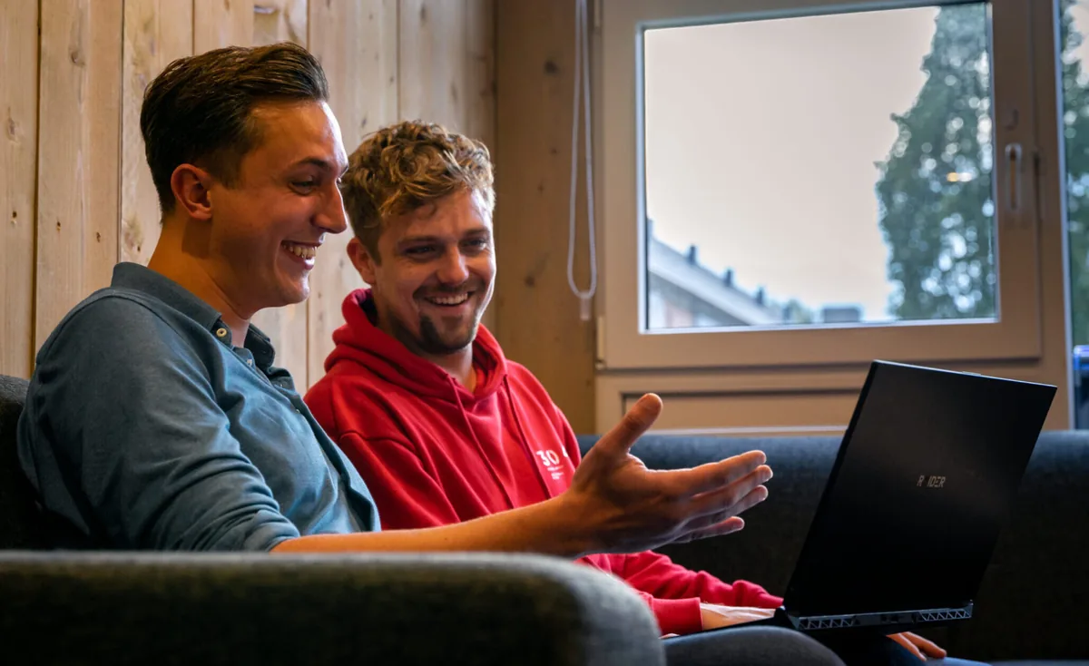 Richard en een collega van Studio Progressus kijken lachend naar een laptop